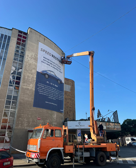 mobilní plošina v centru  České Lípy použitá k věšení plachty na fasádu domu